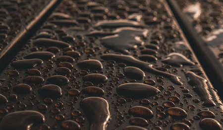 A closeup shot of drips of water on a wooden surfaceの写真素材