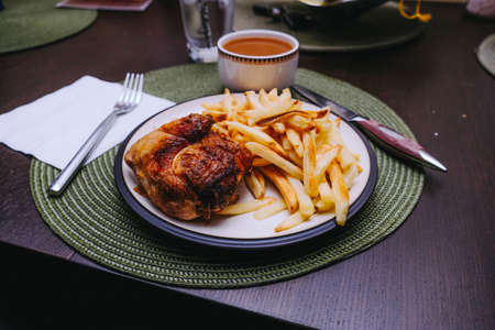 An overhead shot of delicious meat with potato fries and sauce with a blurred backgroundの写真素材
