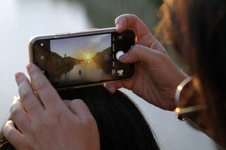 A selective focus shot of a person taking a photo with its smartphone