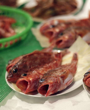 A vertical shot of cooked fish put on a plate over the table