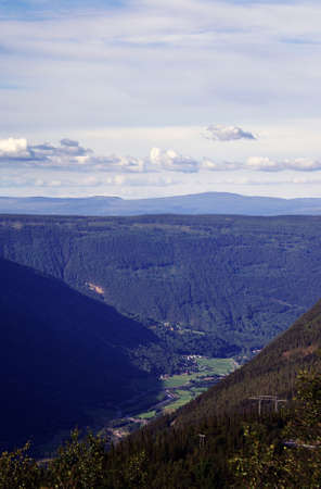 A vertical high angle shot of a mountainous landscape and a lake in Norway