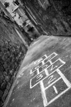 A vertical shot of an alleyway with hopscotch painted on the groundの写真素材