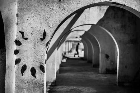 A grayscale shot of an arched type hallway with a blurred backgroundの写真素材