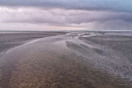 Calm waters of the ocean under a sky full of cloudsの写真素材