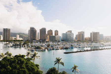 A beautiful shot of city buildings with lots of boats in the seaの写真素材