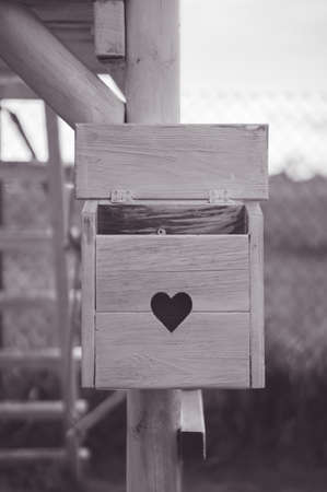 A vertical shot of a wooden mailbox with a cute heart on it in greyの写真素材
