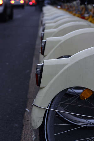 White metal parts of many bicycles parked next to each other on the street