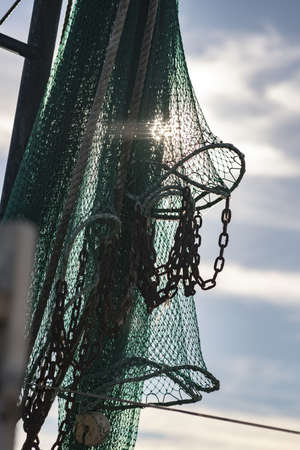 A vertical closeup shot of fishing nets and the cloudy sky in the backgroundの写真素材