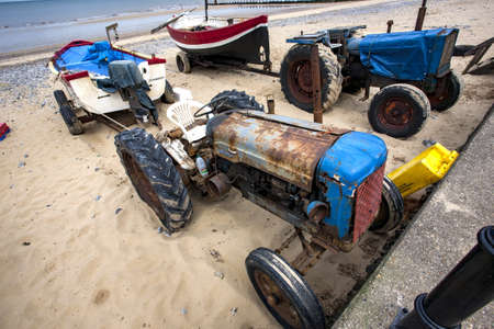 Rusted tractors with boats in the beach at Cromer, North Norfolk, UKの写真素材