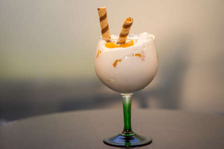 A glass of cocktail on the table under the lights with a blurry background