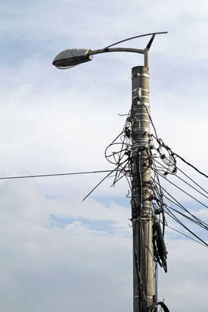 A vertical shot of a pole with wires wrapped background.の写真素材