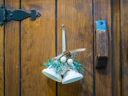 A beautiful Christmas bell decoration on a wooden door