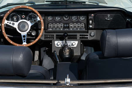 A closeup shot of the black interior of a car, including the seats and the steering wheel