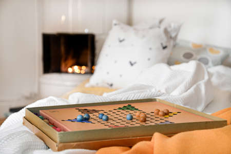 A board game on a bed with pillows on a blurred background