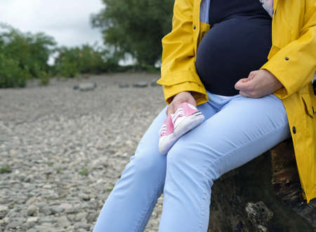 A pregnant woman sitting with a yellow jacket on