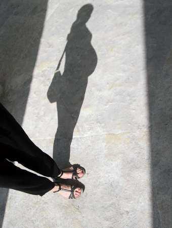 A vertical shot of the shadow cast by a pregnant womanの写真素材