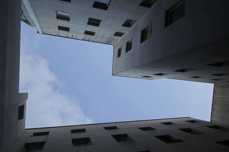 A low angle shot of a white apartment with a blue sky in the background
