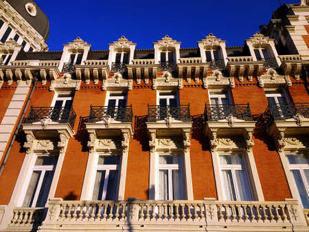 A low angle shot of a building in Spain painted brown under a clear blue sky