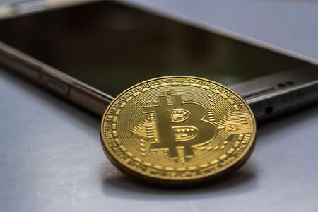 A closeup shot of a large coin placed on top of a mobile phone