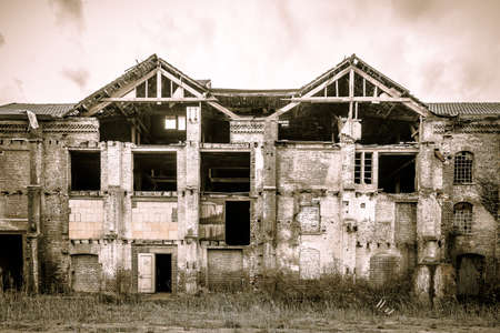 A closeup shot of an old building most of which has been ruined under a cloudy skyの写真素材