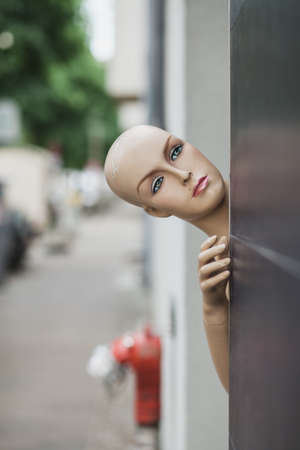 A vertical shot of female mannequin near a black wallの写真素材