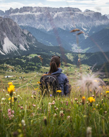A beautiful shot of a woman looking at mount Seceda in Rainelles, Italyの写真素材