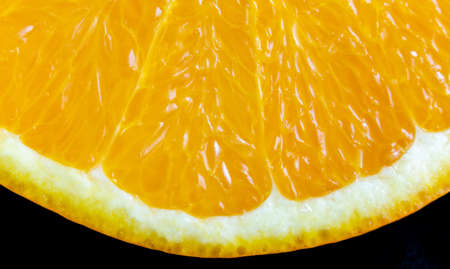 A macro shot of juicy orange on a black background