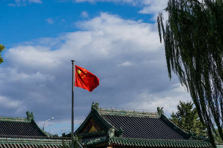 The Chinese flag flies over a traditional temple in Beijing Chinaの写真素材