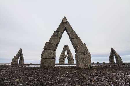 The Arctic Henge surrounded by a field covered in the snow under a cloudy sky in Icelandの写真素材