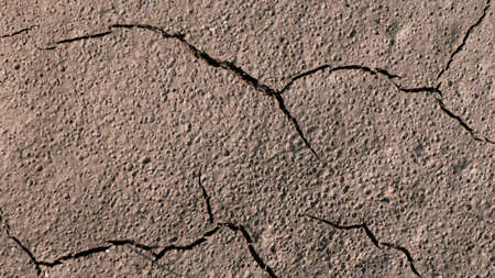 A closeup of cracks in the old brown wall under the sunlight
