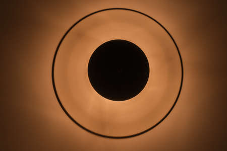 A low angle shot of a lit lamp on the ceiling