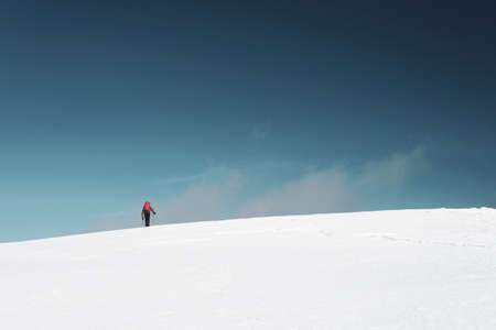 A man hiking on the mountains covered in snow