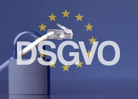 The DSGVO acronym against the EU flag and a padlock and  cableの写真素材