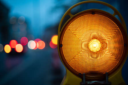 A closeup shot of yellow light in the dark surrounded by cars