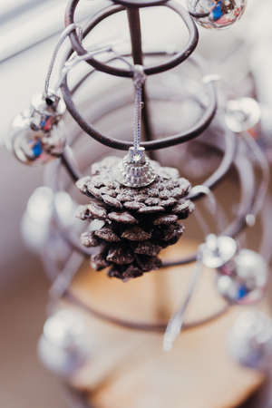 A metal tree decorated for Christmas near the windowの写真素材