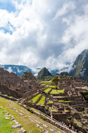 A vertical shot of the mesmerizing Machu Picchu mountain on a cloudy dayの写真素材