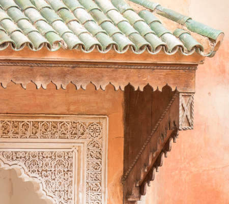 A closeup shot of the front part of a building with a green roof and coral wallsの写真素材