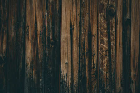 A closeup shot of a wood fence with charred baseの写真素材