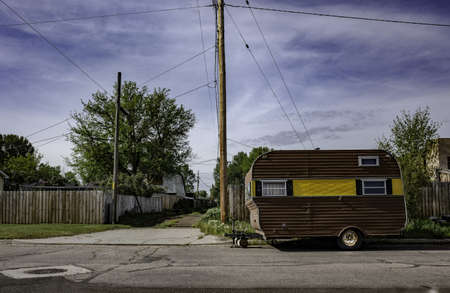 A small caravan house parked on the road in a rural area
