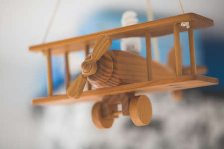 A closeup shot of a wooden miniature old airplane with a blurred backgroundの写真素材