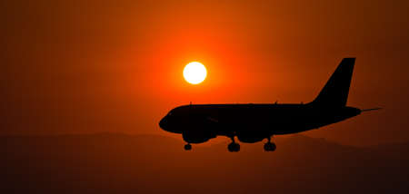 A beautiful silhouette of an airplane flying during nighttimeの写真素材