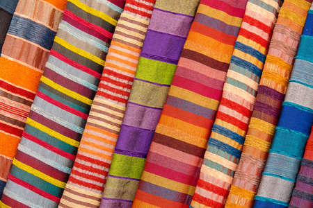 A closeup shot of different colorful Asian textiles with stripesの写真素材