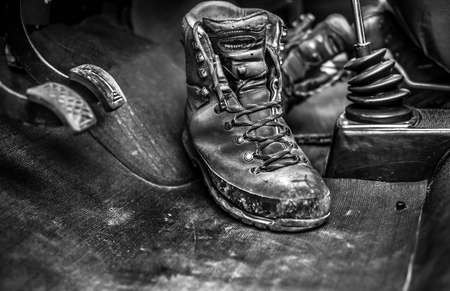 TRENTO, ITALY - Sep 17, 2017: black and white image of a pair of dirty mountain walking shoes in the interior of a carの写真素材