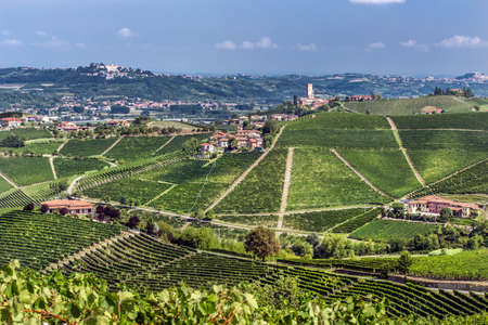 A beautiful shot of grassy hills with buildings under a blue skyの写真素材