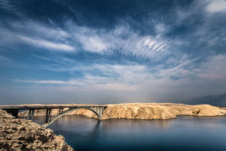 A beautiful shot of the Pag Bridge in Rtina Croatia under a blue cloudy skyの写真素材