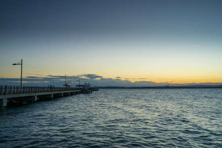 A panoramic shot of a port with a setting sun on the horizon