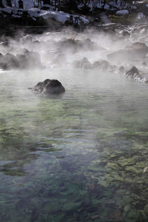 A vertical shot of water with rocks and a mistの写真素材