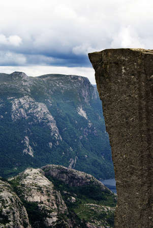 A beautiful scenery of the famous Preikestolen cliffs near a lake under a cloudy sky in Stavanger, Norwayの写真素材
