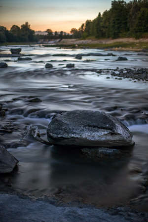 A vertical shot of rocks in the water stream with a blurred backgroundの写真素材