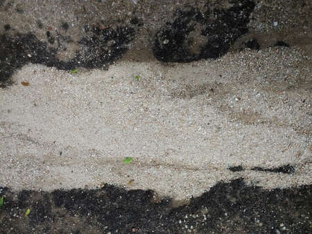 A closeup shot of black and white sand having different objects on itの写真素材